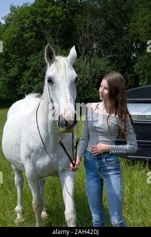 Happy Teenager stehen auf einer Wiese mit Pferd Stockfoto