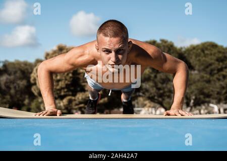 Portrait von barechested muskulösen Mann tun pushups im Freien Stockfoto