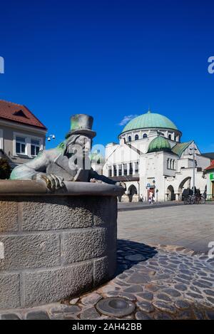 Die Slowakei, Trencin, Vodnik Brunnen mit Trentschiner Synagoge im Hintergrund Stockfoto