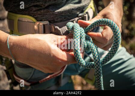 Frau vorbereiten zu klettern, Kontrolle Seil, acht Knoten Stockfoto