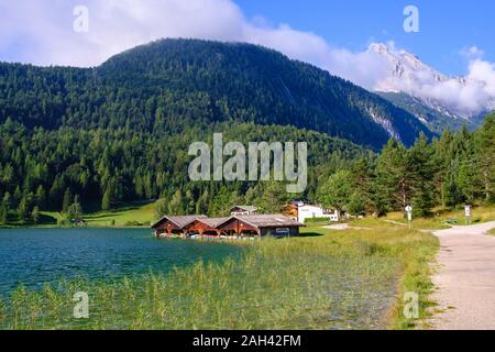 Deutschland, Bayern, Mittenwald, Lakeshore Bootshäuser mit bewaldeten Wettersteingebirge im Hintergrund Stockfoto