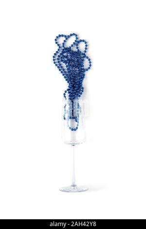Blau neue Jahr Perlen in Champagner Glas. Zusammenfassung Karte auf weißem Hintergrund. Minimale flach und Farbe des Jahres Konzept 2020. Weihnachtsdekoration compo Stockfoto