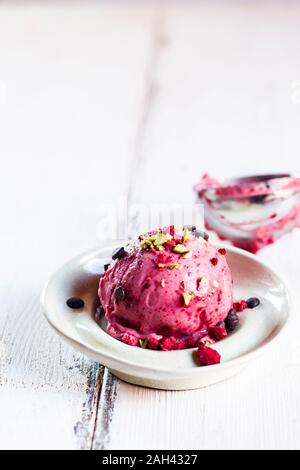 Platte von vegan Zuckerfrei schöne Creme mit Himbeeren, Bananen, sprengte Pistazien und Schokolade Stockfoto