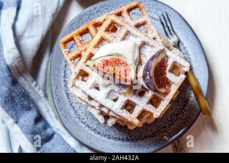 Platte der Dicke Belgische Waffeln mit Schlagsahne, Puderzucker und Feigen Stockfoto
