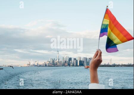 Hand winken LGBT-Flagge in NYC, USA Stockfoto