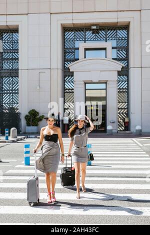 Zwei modischen jungen Frauen mit Gepäck am Flughafen Stockfoto