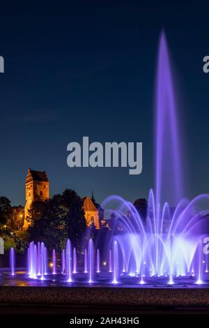 Polen, Woiwodschaft Masowien, Warschau, lila Brunnen in Multimedia Brunnen Park bei Nacht mit Saint Marys Kirche im Hintergrund Stockfoto