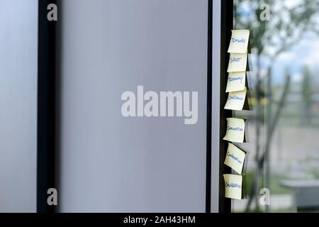 Haftnotizen auf Glas Wand im Büro Stockfoto