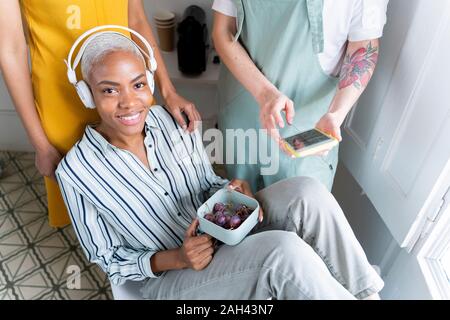 Porträt der lächelnde Frau mit Kopfhörer mit Lunch Box Stockfoto