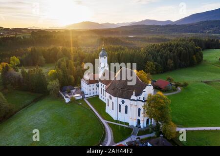 Deutschland, Bayern, Oberbayern, Pfaffenwinkel, Wies, Luftaufnahme der Wieskirche Zum Gegeißelten Heiland bei Sonnenaufgang Stockfoto