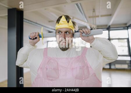 Mann verkleidet sich als Ballerina mit spielzeugschwert im Büro Stockfoto