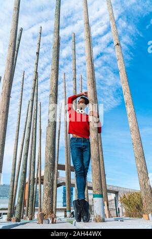 Junge Mann auf Zehenspitzen zwischen Holzpfähle Stockfoto