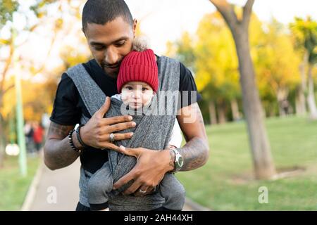 Junger Vater mit Sohn in ein Baby Sling Stockfoto