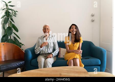 Porträt von zwei lachende Frauen sitzen auf der Couch Stockfoto