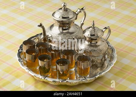 Marokkanisches Teetablett mit zwei teekannen mit und ohne Zucker, und Gläser mit und ohne absinthium Kraut Stockfoto