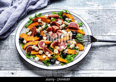 Platte von bunten herbstlichen Salat mit Feigen, Schafskäse, Rucola, Blaubeeren und Hokkaido Kürbis Stockfoto