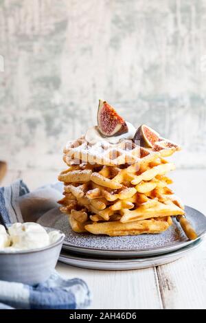Platte der Dicke Belgische Waffeln mit Schlagsahne, Puderzucker und Feigen Stockfoto
