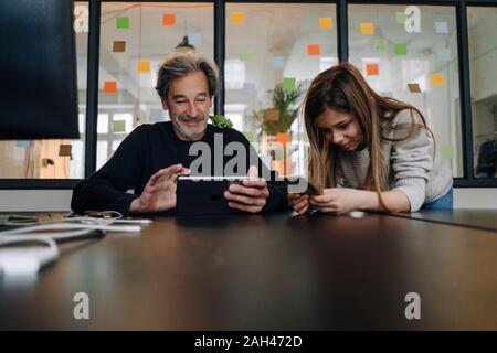 Casual senior buisinessman und die Verwendung von Tablet-PC und Smartphone im Büro Mädchen Stockfoto