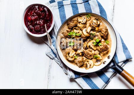 Pfanne mit schwedischen kottbullar Fleischbällchen in mushroom Gravy und Schüssel Kartoffelpüree Preiselbeeren Stockfoto