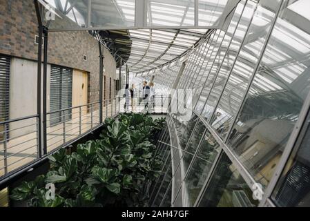 Geschäftsleuten stehen auf einer Fußgängerbrücke in modernen Bürogebäude Stockfoto