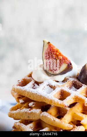 Stapel von Dicke Belgische Waffeln mit Schlagsahne, Puderzucker und Feigen Stockfoto