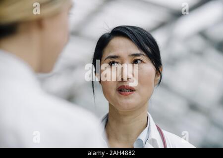 Porträt der Ärztin im Gespräch mit einem Kollegen Stockfoto
