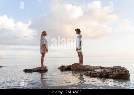 Ein junges Paar steht auf Felsen am Meer, Ibiza, Balearen, Spanien Stockfoto