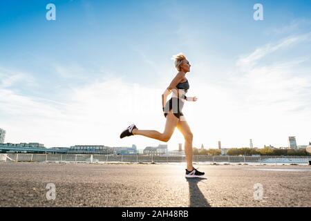 Blonde Frau joggen in Köln, Deutschland Stockfoto