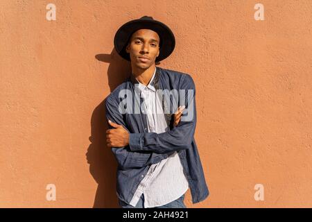 Portrait von stilvollen junge Mann mit dem Hut an einer Wand Stockfoto