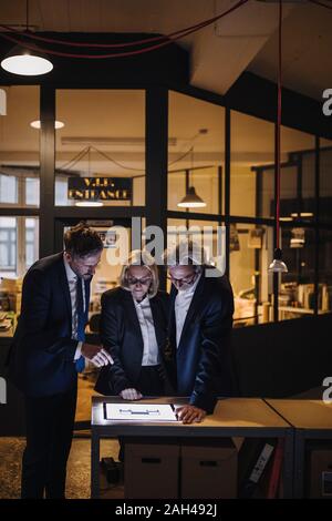 Geschäft Leute mit leuchtenden Tablet sprechen in Office Stockfoto