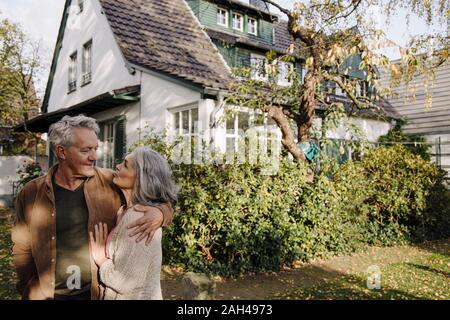 Ältere Paare im Garten ihres Hauses im Herbst Stockfoto