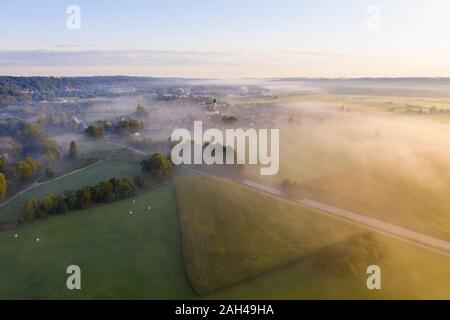 Deutschland, Bayern, Geretsried, Luftaufnahme von grünen Feldern und Loisach river canal eingehüllt in Nebel am Morgen Stockfoto