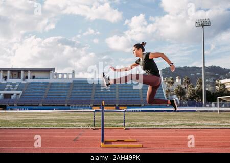 Weibliche hürdenspringer beim Training auf der Tartanbahn Stockfoto