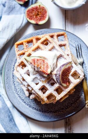 Platte der Dicke Belgische Waffeln mit Schlagsahne, Puderzucker und Feigen Stockfoto