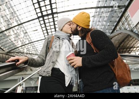 Junges Paar küssen auf einer Rolltreppe im Bahnhof, Berlin, Deutschland Stockfoto