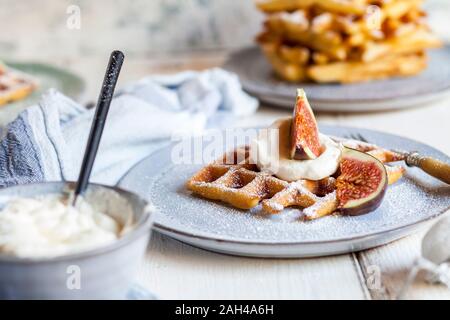 Dicke belgische Waffel mit Schlagsahne, Puderzucker und Feigen Stockfoto
