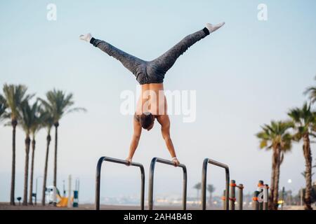 Junger Mann üben calisthenics an ein Fitnessbereich im Freien Stockfoto