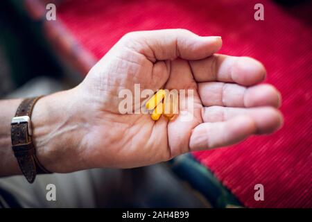 Senior holding Pillen in seiner Hand. Stockfoto