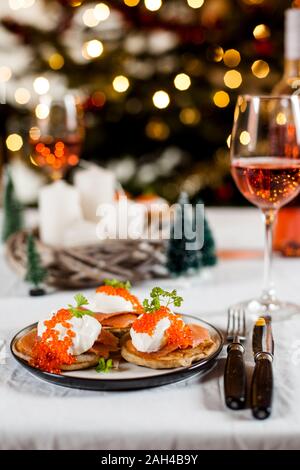 Blinis mit Sauerrahm, geräuchertem Lachs und Fischrogen, vor Weihnachten Dekoration Stockfoto