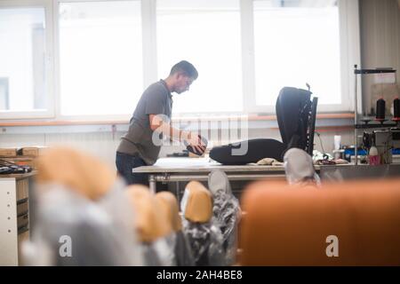 Junge Mann in einem Polster workshop Stockfoto