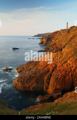 Am späten Abend Sonnenlicht auf den Klippen von Pendeen mit Levante Zinnmine in der Ferne, Cornwall, England, Vereinigtes Königreich. Stockfoto