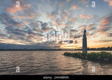 Deutschland, Hamburg, Außenalster mit Skulptur Drei Männer im Boot von Edwin Paul Scharff bei Sonnenuntergang Stockfoto