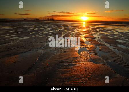 Die untergehende Sonne reflektiert den Strand in Redcar, Teeside, North Yorkshire, England, Vereinigtes Königreich. Stockfoto