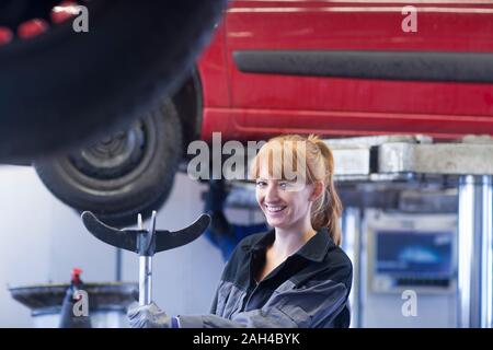 Lächelnd weibliche Automechaniker in Werkstatt Stockfoto