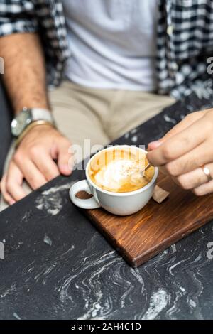 Man genießt Tasse Cappuccino, close-up Stockfoto