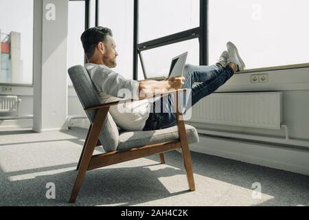 Reifen Geschäftsmann mit Laptop in leeren Büro Stockfoto