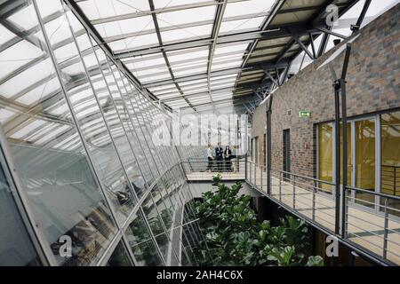 Geschäftsleuten stehen auf einer Fußgängerbrücke in modernen Bürogebäude Stockfoto