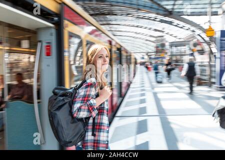 Selbstbewusste Geschäftsfrau, die sich an ein Gebäude in der Stadt lehnt Stockfoto