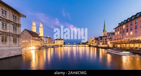 Schweiz, Kanton Zürich, Zürich, Limmat zwischen beleuchtete Altstadt waterfront Gebäude in der Dämmerung Stockfoto