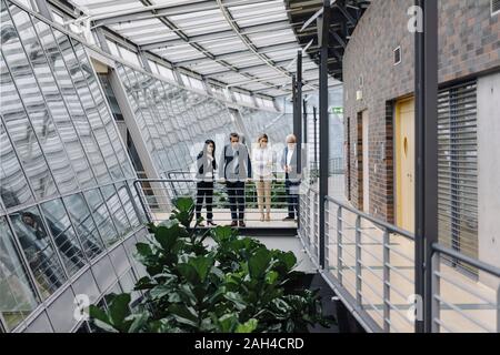 Geschäftsleuten stehen auf Skywalk in modernen Bürogebäude Stockfoto